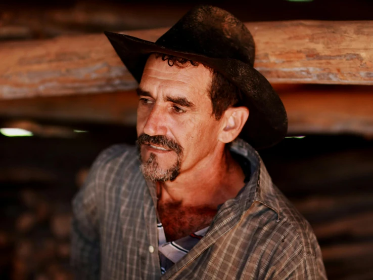 a man wearing a hat and a shirt with a plaid tie