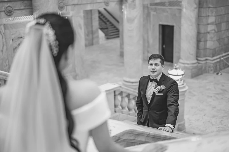 a young groom standing by the steps at a church