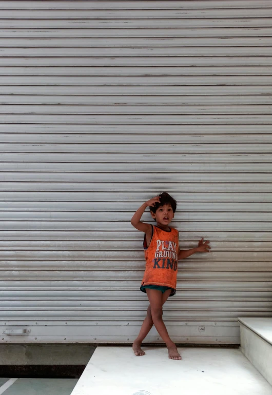 a little boy standing on some steps next to a wall