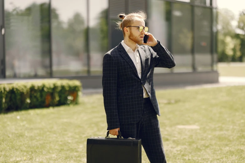 the man has a suitcase and speaks on his cell phone