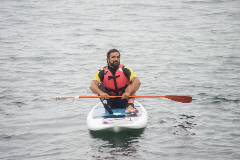 the man is rowing in the lake on his canoe