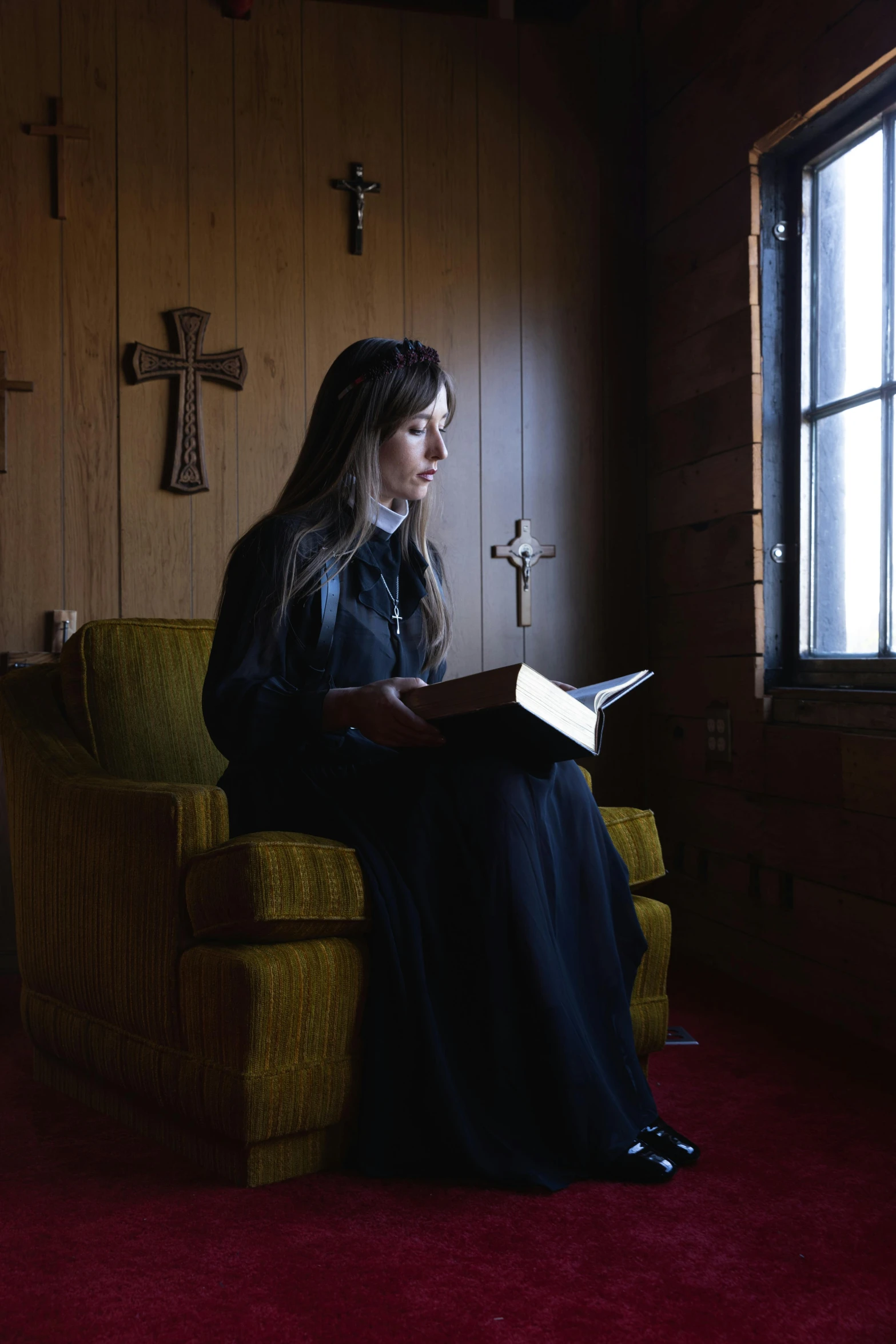 a woman sits in a chair holding a book