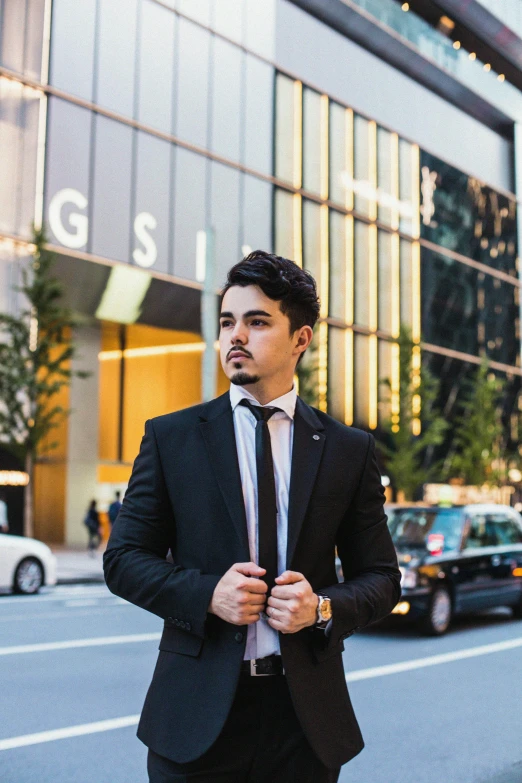 a man standing on the sidewalk next to a street