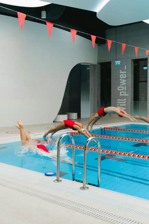 swimmers jumping into a swimming pool on a race