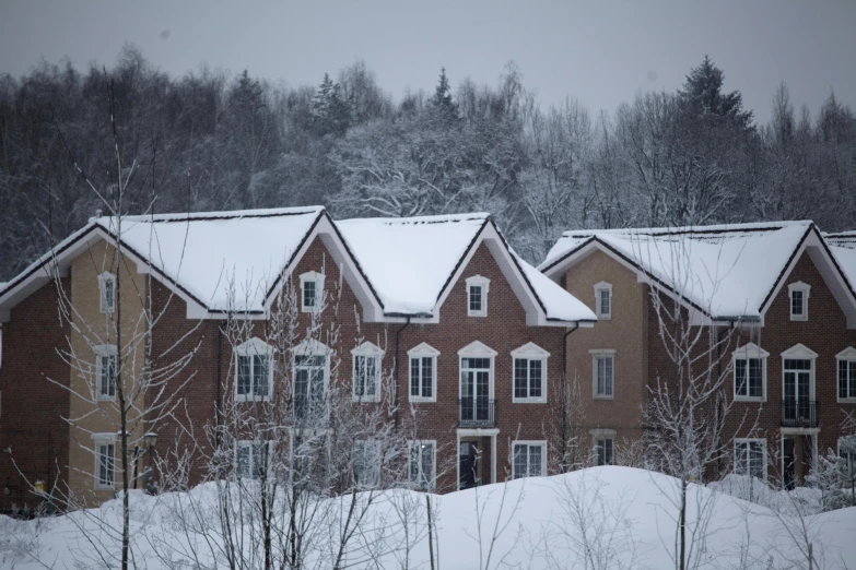 two red brick homes are covered in snow