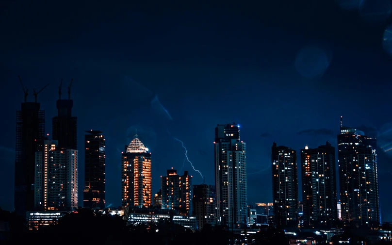 a city skyline with skyscrs and some lightning