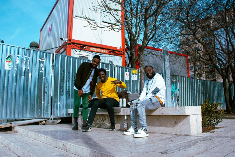 the four young men are hanging out on the steps