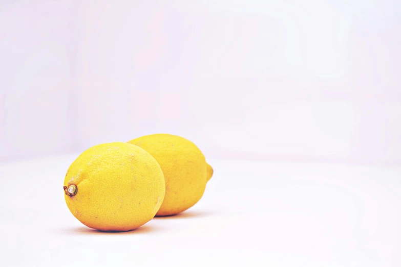 two fruit shaped like lemons are seen here