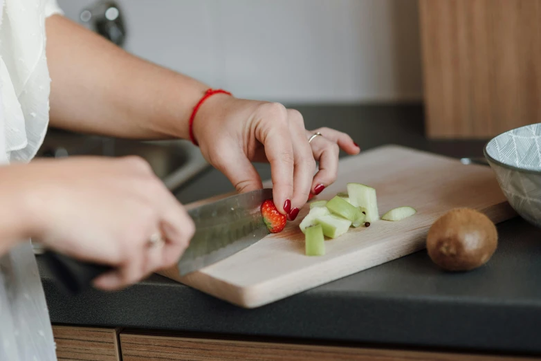 person  up some fruit with a large knife