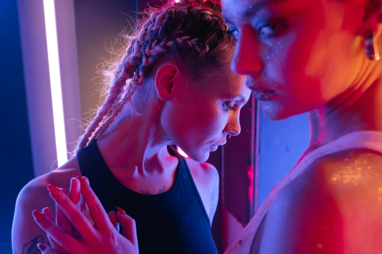 a young woman with dreadlocks standing next to a young woman