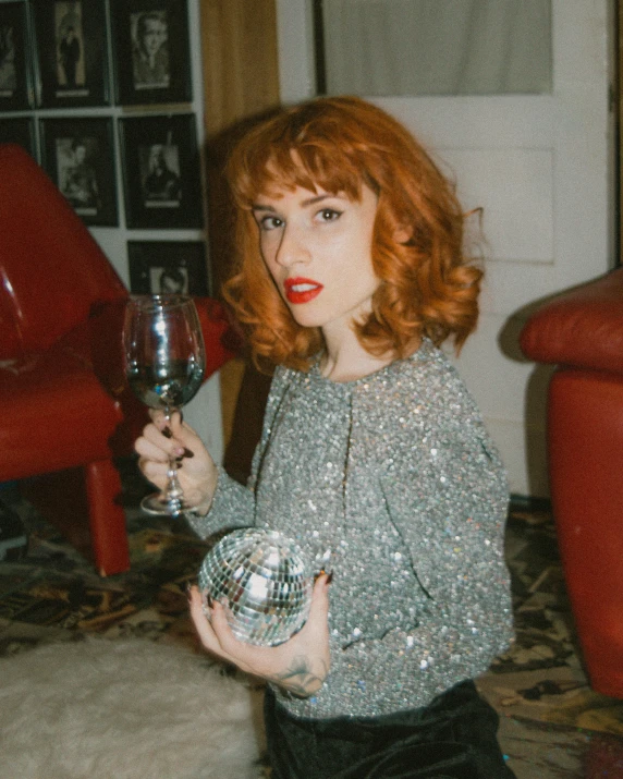 the red - haired woman has a glass in her hands