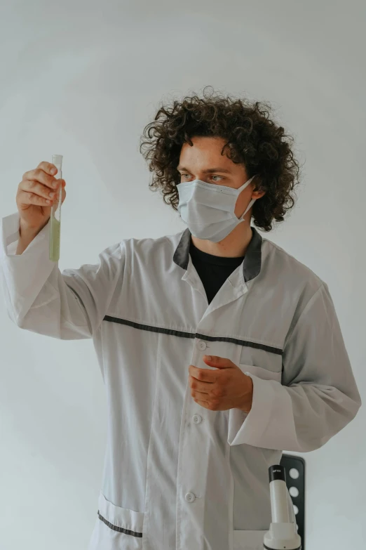 a person in a medical suit holds up a tube