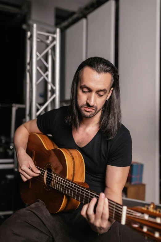 a man with long hair holding a guitar
