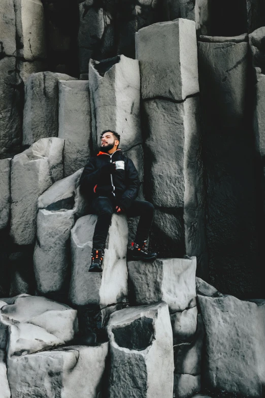 the man sits on some large rock formations