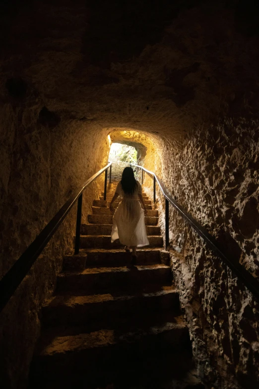 a woman is descending stairs while wearing a dress