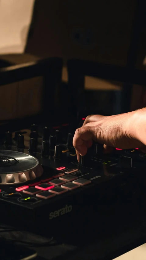 a person with the right hand on an electronic sound mixing unit