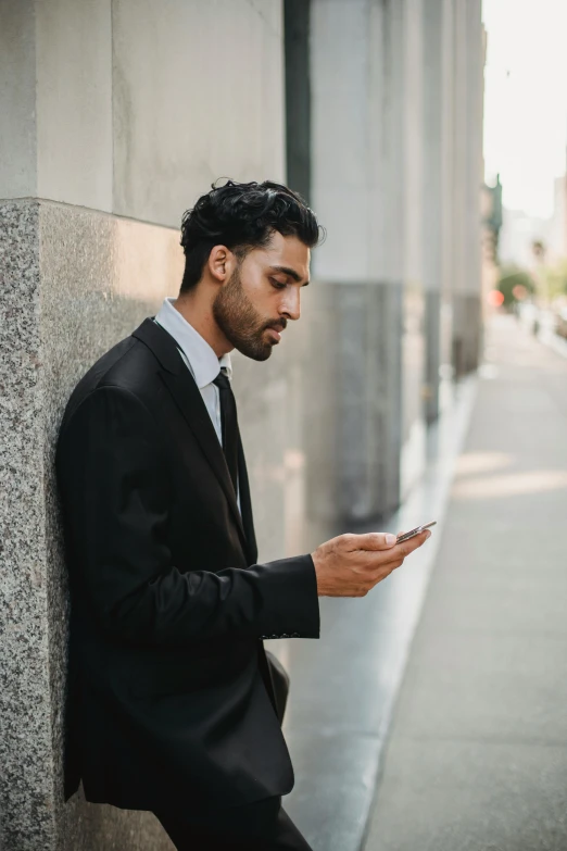 a man in a suit is using his phone