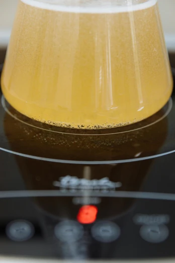 a yellow beer cup on the burner of an electric stove