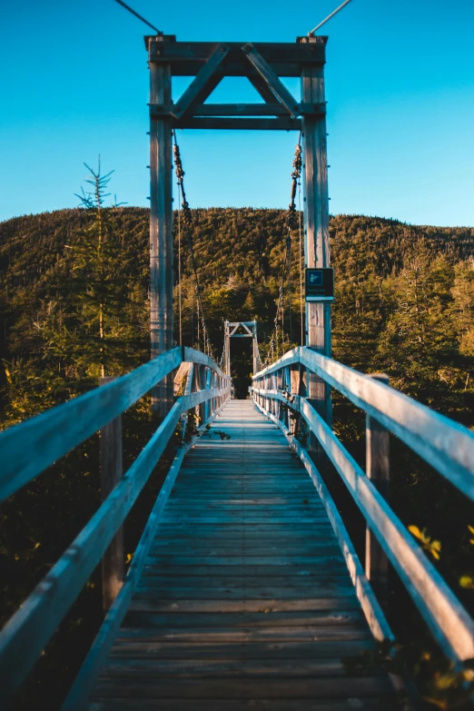 there is a small bridge with many steps in front of mountains