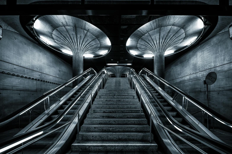 a black and white pograph of two escalators in a building