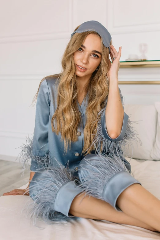 a beautiful young woman sitting on top of a bed wearing tight jeans