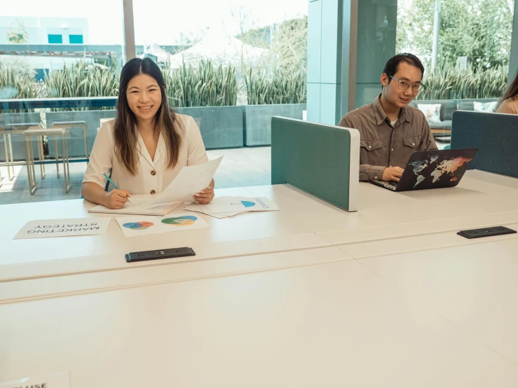 two people sit at the table while looking over papers