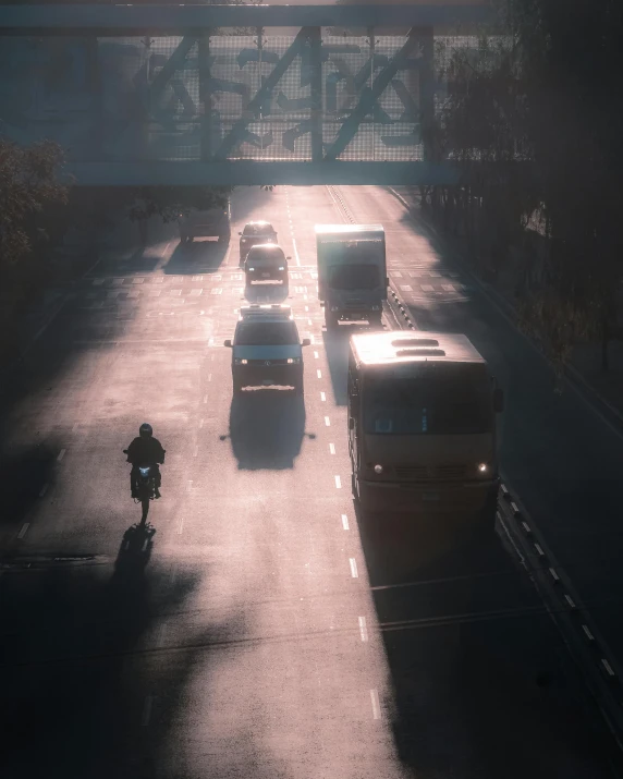 people riding motorcycles are on the road under a bridge