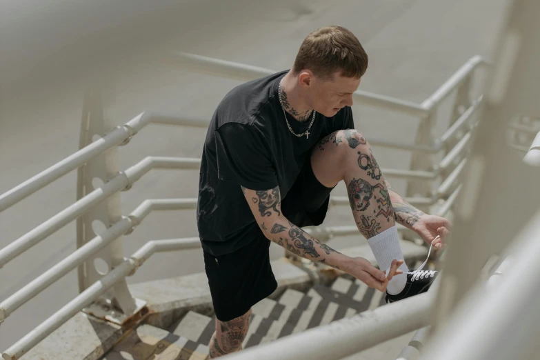 a man walking down some stairs while putting on his shoes