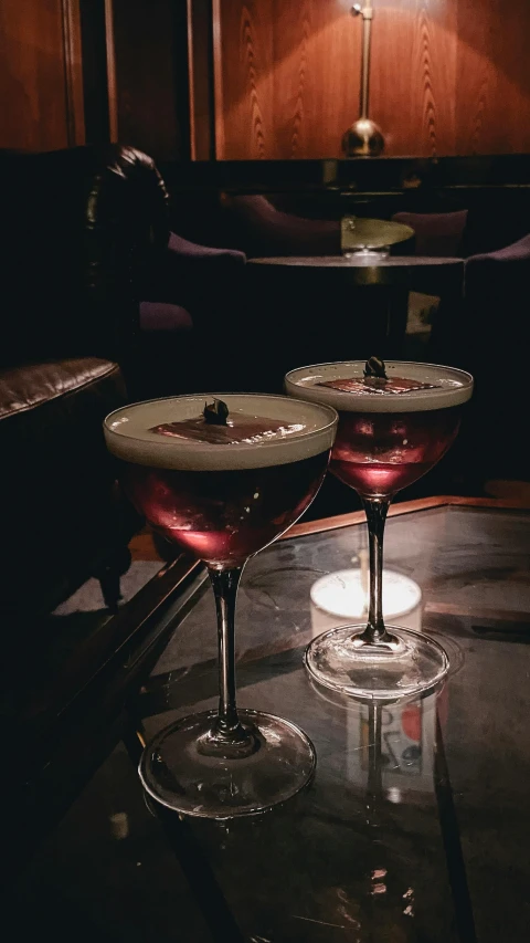 two martini glasses with the colors of pink in them