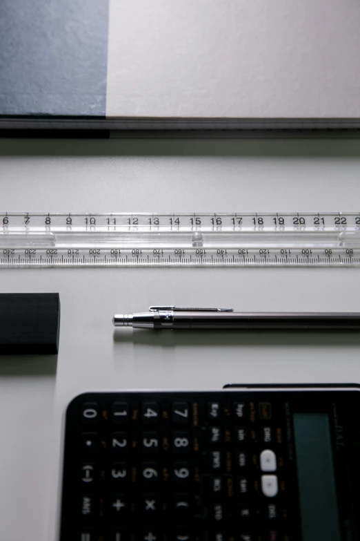a pen and ruler on top of a white desk