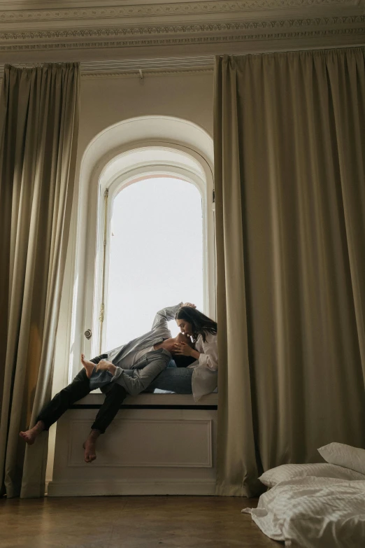 a person sitting on the bed with their feet hanging back