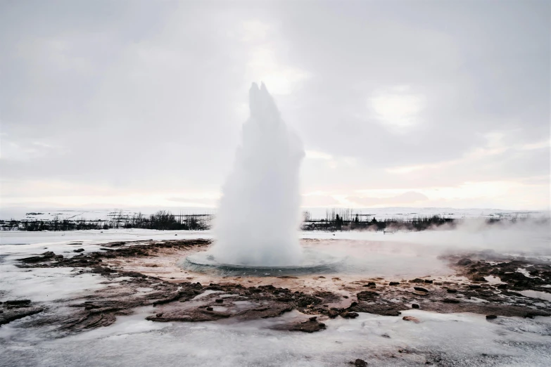 a very old geyser on the ground with steam in it