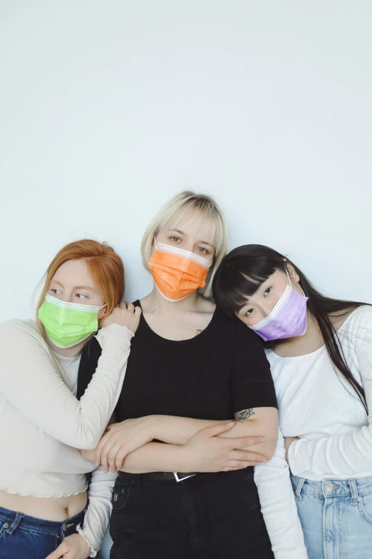 a group of three women with masks on their face