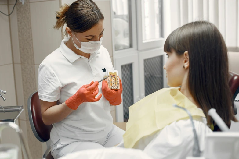 a woman is in a dentist chair while she puts an extra bandage on her mouth