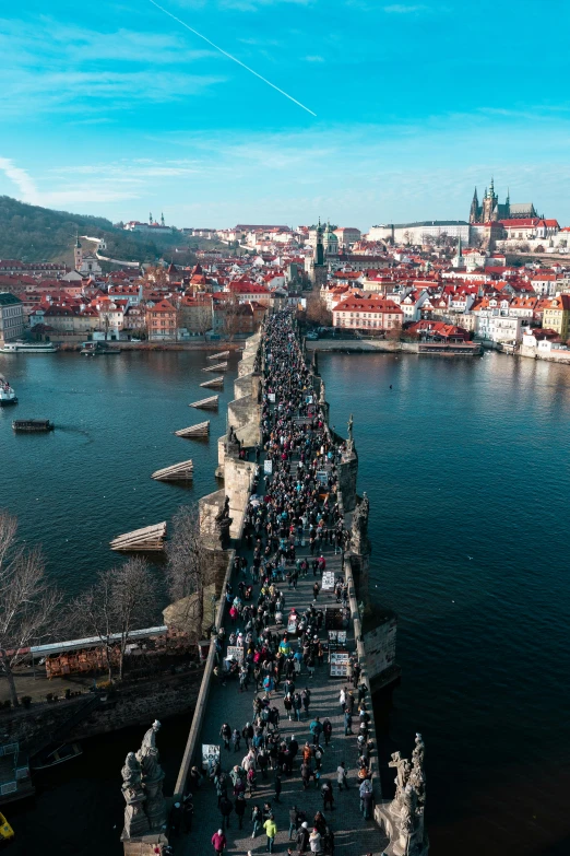 a group of people standing on the side of a bridge