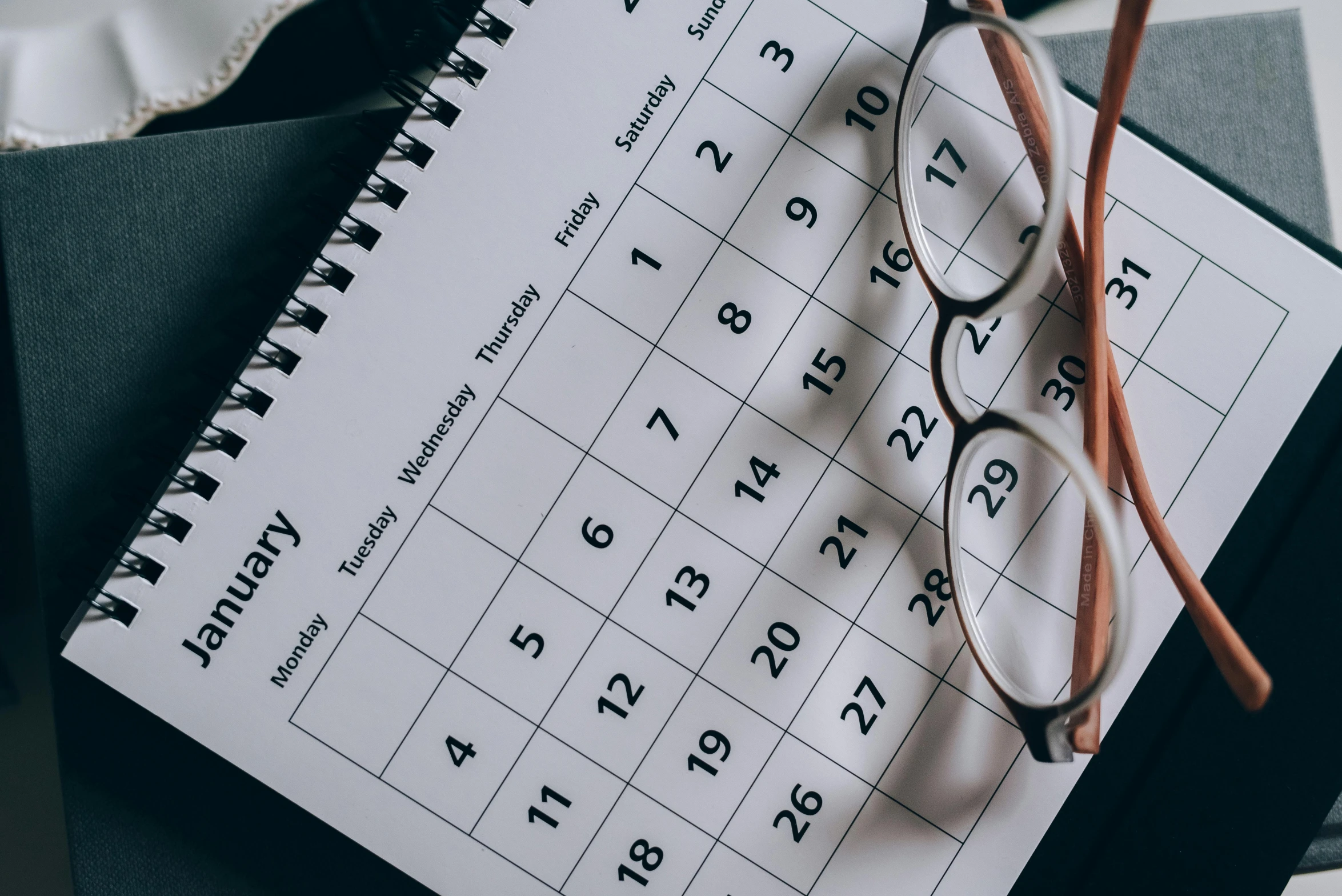 a desk calendar with glasses on top