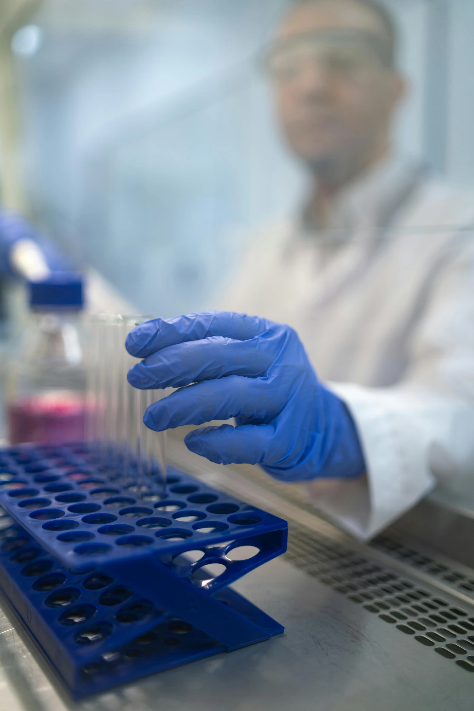 scientist in lab jacket working on a piece of plastic