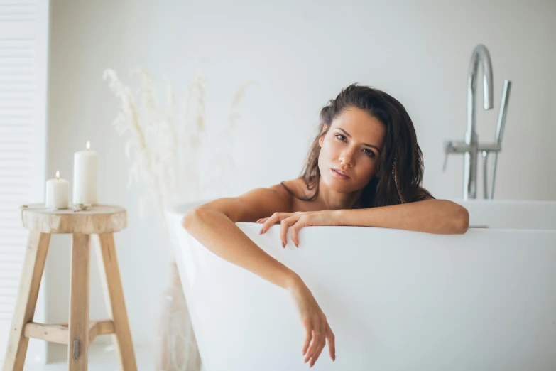 a woman with long hair is laying in a bathtub