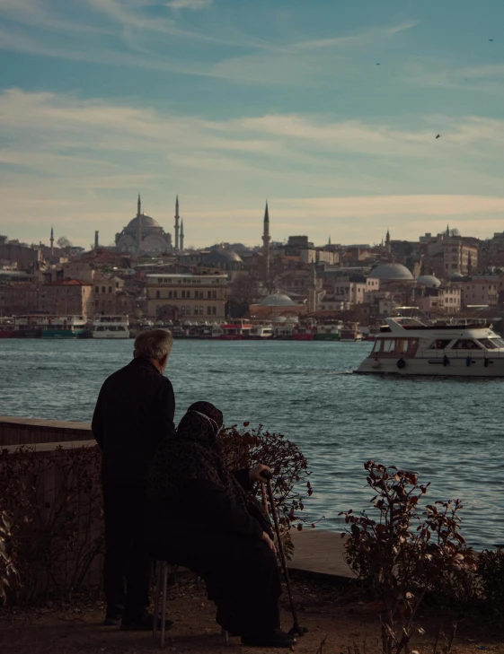 the man is looking at a small boat in the water