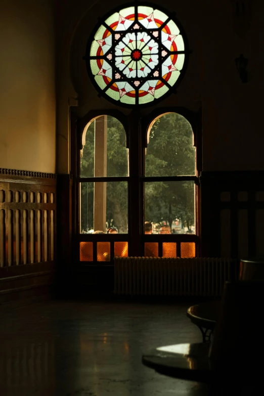 a large window in the middle of a hall, reflecting the outside