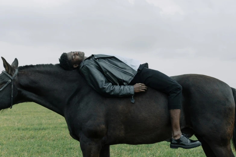 a man is lying on a horse in a field