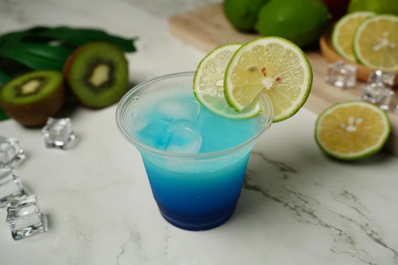 a drink with a slice of lime, mint and blue liquid