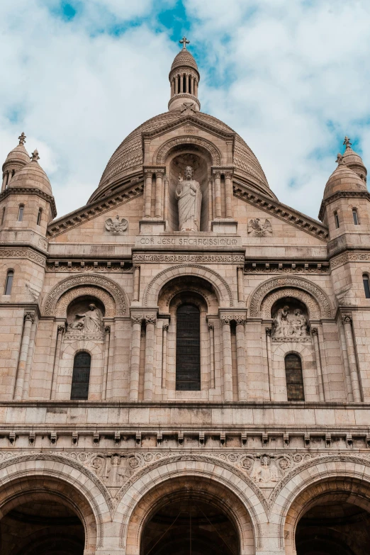 the large and massive building has four statues on the front