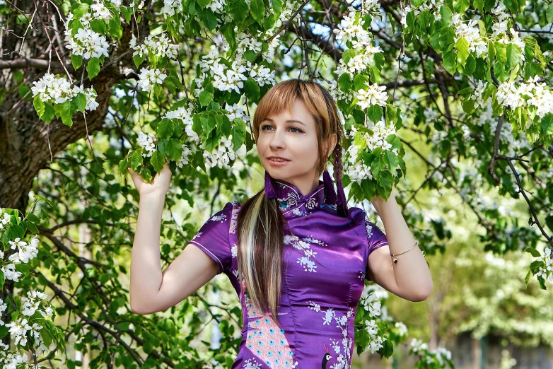  in oriental dress under white flowers