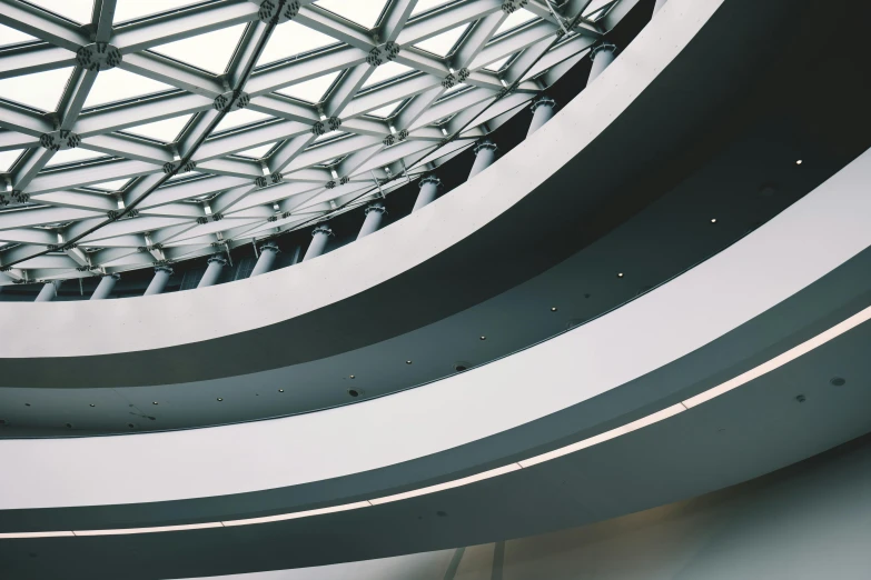 a circular ceiling with white and gray stripes in a lobby