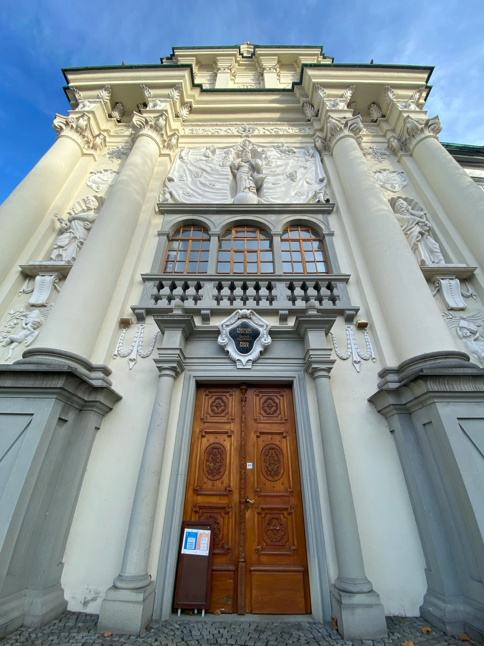 a building is covered with many doors, and has a clock