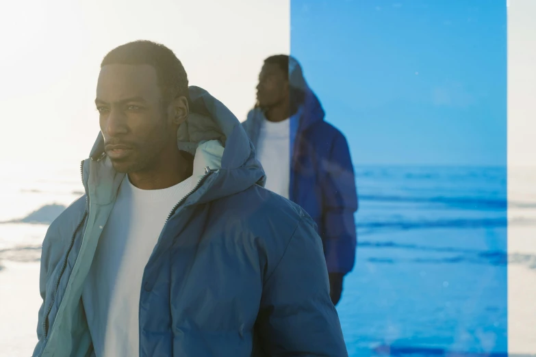 a man wearing a blue coat in the sand