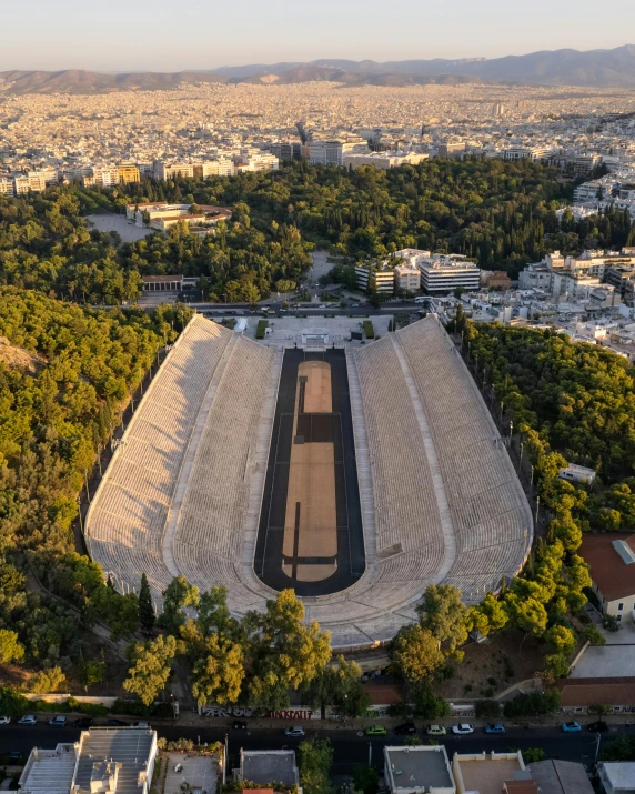 an aerial view of an arena in the middle of trees