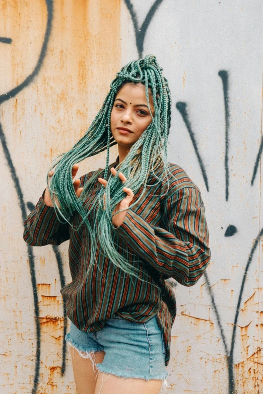 young woman posing in front of a graffiti covered wall