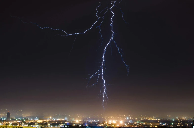 lightning hitting across the night sky over the city